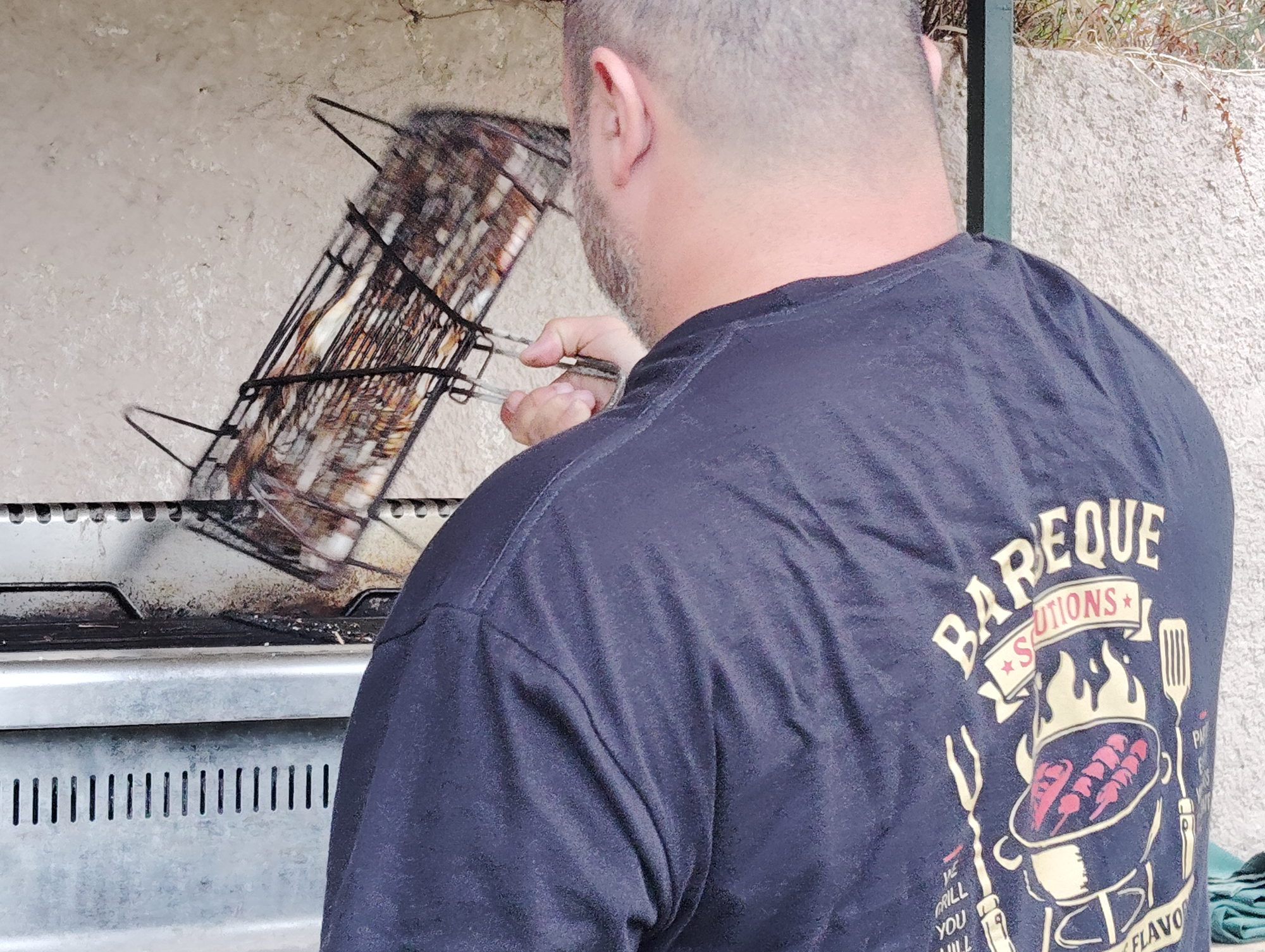 The chef lifting a grill basket of prawns at a private BBQ in Corfu