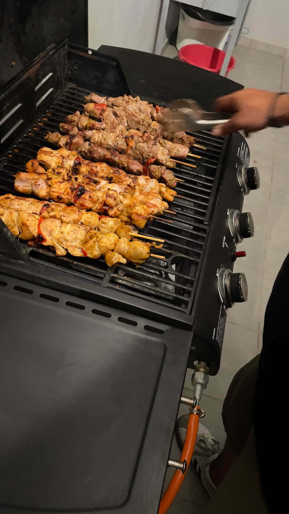A barbecue grate filled with chicken and pork souvlaki skewers at a private BBQ in Corfu