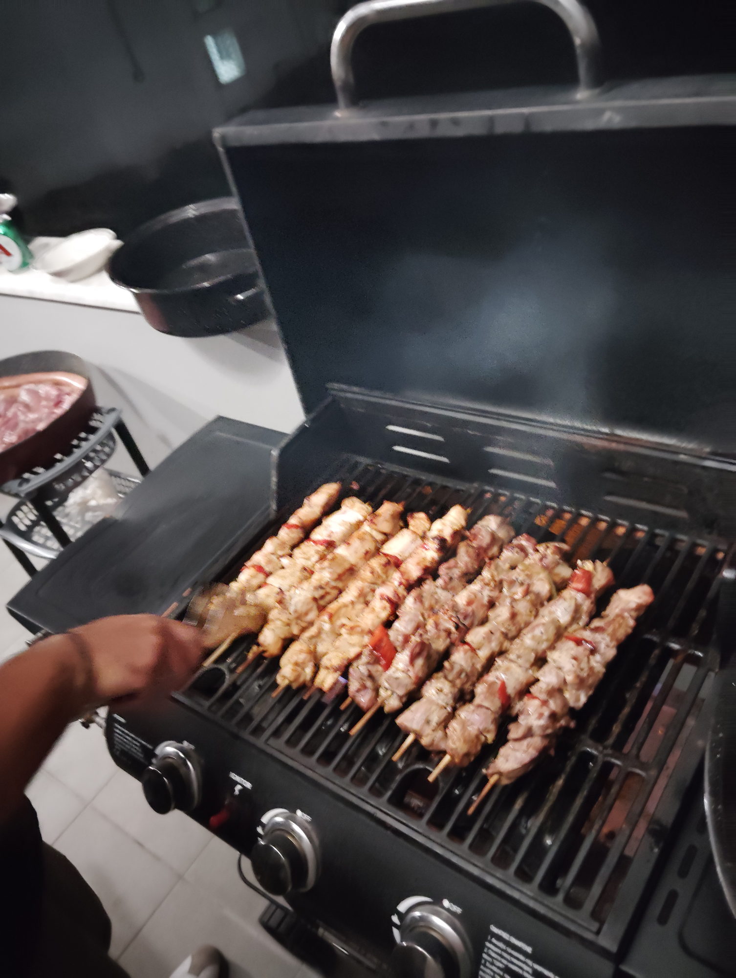 Souvlaki skewers on the grate with smoke rising from the grill
